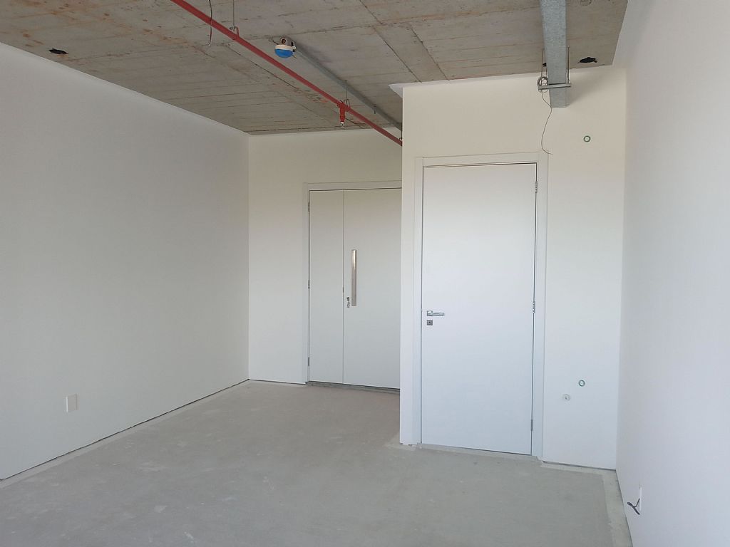 Vista da sala comercial com porta de entrada e lavabo